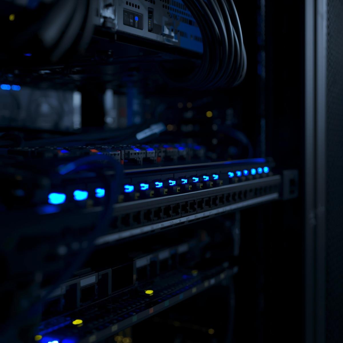 modern enterprise network switch in a data center rack, neatly organized ethernet cables, blue led lights, high detail, cinematic lighting, clean composition, realistic, no people, prof